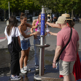 Personas en París hidratándose este martes en París durante la ola de calor.