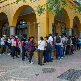 Personas migrantes hacen cola para la tramitación de su regularización administrativa en Sevilla