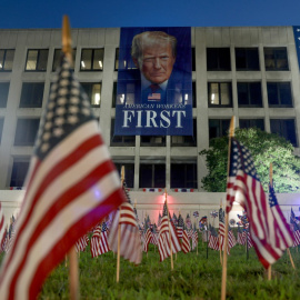 Banderas estadounidenses frente a una pancarta del presidente de EEUU Donald Trump en edificio del Departamento de Trabajo, en vísperas del 4 de julio.