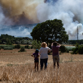 Varias personas observan el humo del incendio en La Bisbal d'Empordà, Girona, a 3 de julio de 2026.