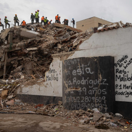 Personas realizan labores de búsqueda entre los escombros de edificios destruidos por terremotos este lunes, en La Guaira (Venezuela).