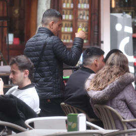 Camarero atendiendo a clientes en una terraza.