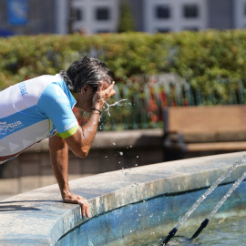 Un ciclista se refresca en la fuente de la Escandalera de Oviedo, Asturias.