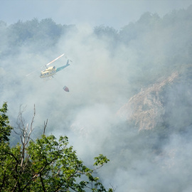 Un helicóptero ayuda en las labores para extinguir el incendio forestal en Ribota de Sajambre, León, Castilla y León (España).