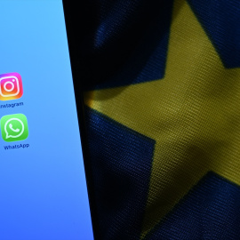 Meta AI, Instagram, Facebook y WhatsApp en un móvil sobre una bandera de la Unión Europea.
