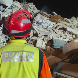 Un bombero junto al edificio derrumbado en Benetússer