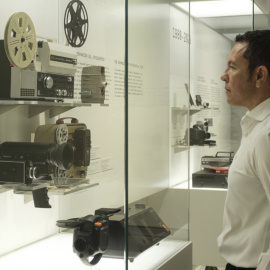 Un visitante observa las cámaras presentes en la exposición «Recuerdos. La vida a través del cine doméstico».  © Fundación ”la Caixa”