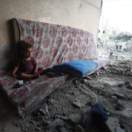 Niño sentado ante los escombros de una casa en Gaza.