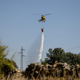 Helicóptero de bomberos trabajando en el incendio forestal de Lozoyuela en el norte de Madrid.