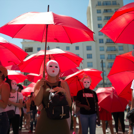 3 de agosto de 2022, Málaga, España: Manifestantes llevan mascarillas y sostienen paraguas rojos durante una protesta contra la propuesta de ley del Gobierno español para abolir la prostitución. Foto: Jesus Merida/SOPA Images vía ZUMA Press Wire/dpa  Foto