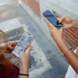 Dos jóvenes miran sus teléfonos móviles en Madrid.