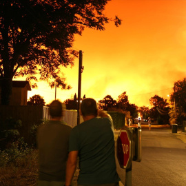 Los vecinos miran el cielo iluminado por un incendio forestal en Le Porge, en el suroeste de Francia, a 23 de julio de 2026.