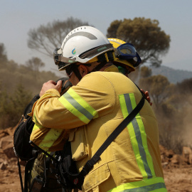 Bomberos se abrazan tras labores de extinción en el incendio de Ávila.