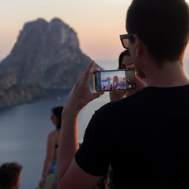 EuropaPress_4623036_joven_hace_fotografia_atardecer_cala_dhort_agosto_2022_ibiza_baleares