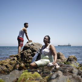 Dos personas en la playa de Tarajal, a 2 de agosto de 2026, en Ceuta.
