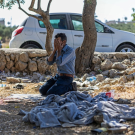 Un palestino reza junto a un montón de ropa de prisionero mientras espera la liberación de su familiar de una cárcel israelí en un puesto de control en las afueras de Ramala, en Cisjordania (8/06/26)
