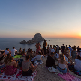 Decenas de personas disfrutan del atardecer en la Cala d'Hort.
