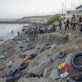 Decenas de migrantes tras haber traspasado la frontera entre Ceuta y Marruecos, a 31 de julio de 2026.