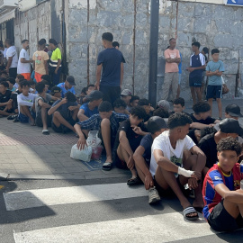 Un grupo de menores espera para ser filiado en una comisaría de la Policía Nacional, a 10 de agosto de 2026, en Ceuta.