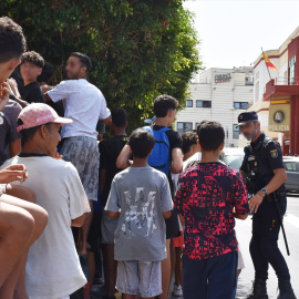Un grupo de menores espera para ser filiado en una comisaría de la Policía Nacional en Ceuta