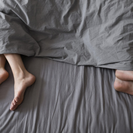 Dos personas separadas en una cama.