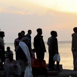 Migrantes desalojados de la playa del Trampolín en Ceuta tras habilitarse un espacio para su acogida el 20 de agosto de 2026.