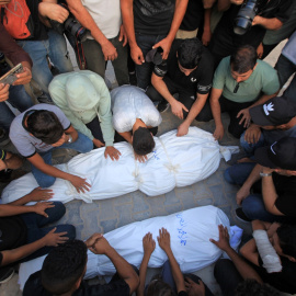 Un grupo de personas lloran la muerte de ciudadanos palestinos asesinados por un ataque aéreo israelí.