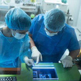 Dos técnicos hospitalarios analizan células cancerosas (Archivo).