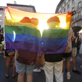 Una pareja tapada con una bandera LGTB en una imagen de archivo.