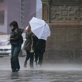 Imagen de archivo de transeúntes sufriendo fuertes lluvias.