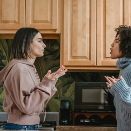 Dos personas discuten acaloradamente en una cocina.