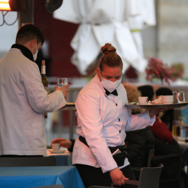 Dos camareros trabajan en la terraza de un bar en el centro de Madrid (España).