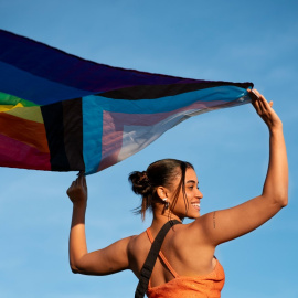 Una persona sujeta una bandera del colectivo LGTBIQA+.