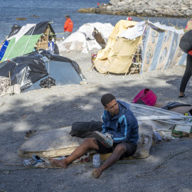 Personas migrantes en campamentos improvisados en la playa.