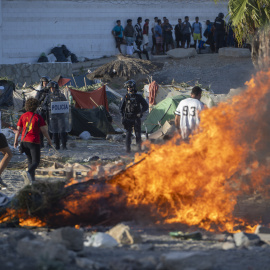 Mobiliario urbano y enseres arden durante una manifestación para protestar por la situación provocada por la llegada masiva de migrantes.