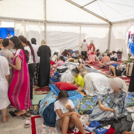 Varios menores migrantes se refugian bajo una carpa, a 27 de agosto de 2026, en Ceuta.