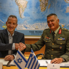 El director general del Ministerio de Defensa de Israel (IMOD), el general de división Amir Baram (izq) y su homólogo griego, Ioannis Bouras (dcha), se dan la mano al firmar el acuerdo de exportación de armamento, Escudo de Aquiles, en Israel (31.08.26)