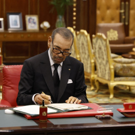 El rey de Marruecos, Mohamed VI, firma unos documentos en el Palacio Real de Rabat.