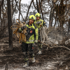 Varios bomberos realizan labores de extinción de incendios.
