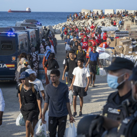 Miembros de la Cruz Roja atienden a varios migrantes, en la playa del Trampolín, en Ceuta.