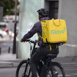 Un repartidor de Glovo en bicicleta por una calle de Madrid.