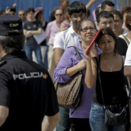 Inmigrantes a la espera de poder realizar trámites en comisaria - EFE