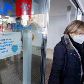 Una mujer con mascarilla sale del hospital.