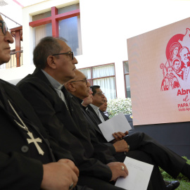 Sacerdotes observan el emblema oficial de la visita de León XIV a Perú.