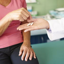 Imagen de una mujer a la que se le suministra un medicamento.