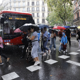 Varias personas caminan bajo la lluvia en Barcelona, 2 de octubre de 2026.