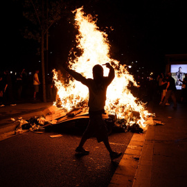 Imagen de un manifestante en Barcelona quemando un contenedor.