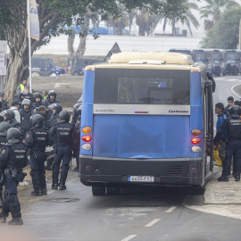 La Policía Nacional escolta los autobuses llenos de personas migrantes desalojadas de la playa del Trampolín.