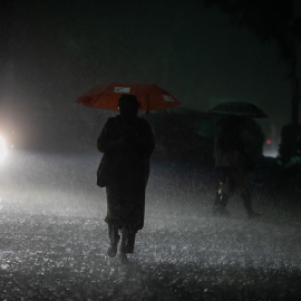 Una imagen de archivo de una mujer caminando bajo la lluvia.