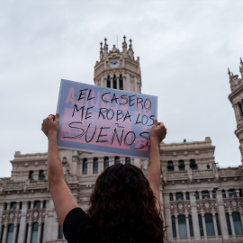 Una persona sostiene una pancarta durante una manifestación por la vivienda.